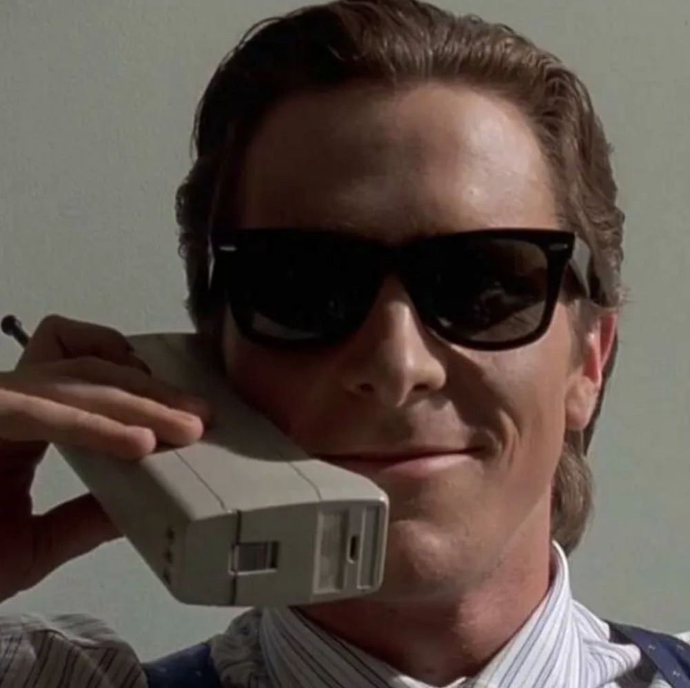 patrick bateman on the phone looking smug